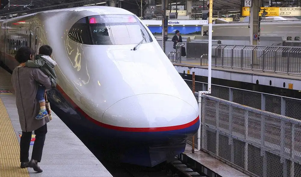 Tokyo, Japan - May 4, 2012: Travelers board Shinkansen Hayate train at Tokyo Station. Hayate has top operating speed of 275km/h and is among fastest trains worldwide.